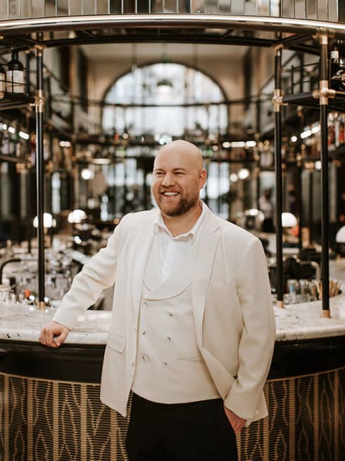 Head Bartender �d�m R�dli dressed in white, standing and smiling