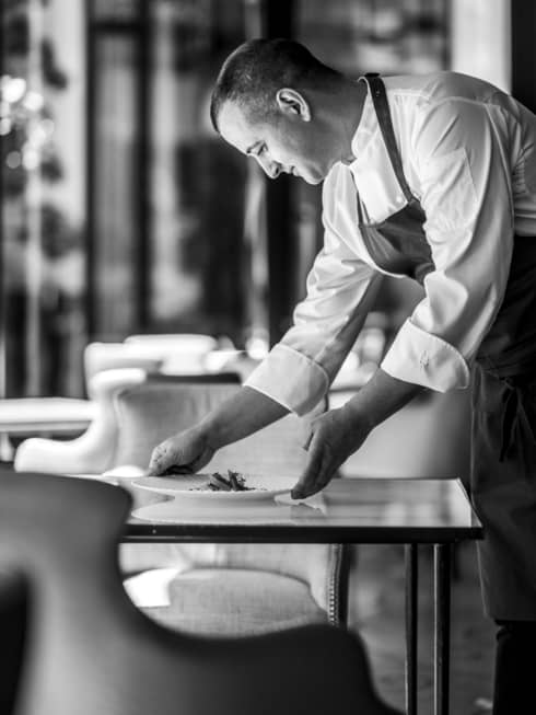 Shot of Chef Alan Taudon setting a plate on a table for two