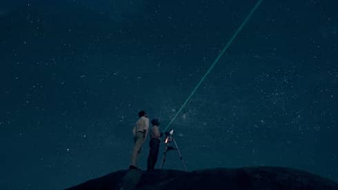 Two people stargazing at night