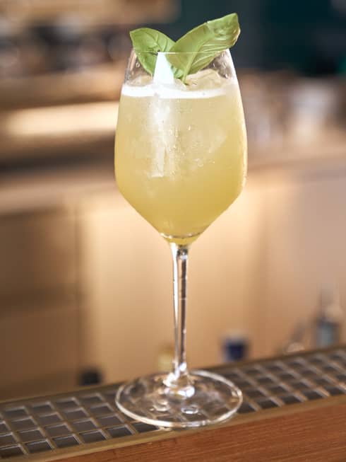 Wine glass with yellow-coloured drink.