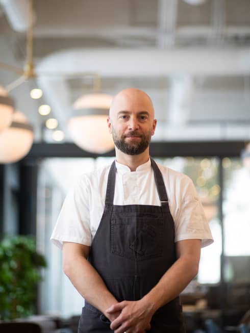 Chef Greg Vernick in white shirt and black apron.