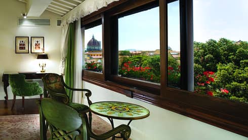 Duomo Duplex Suite, velvet chairs and small mosaic table under wide window