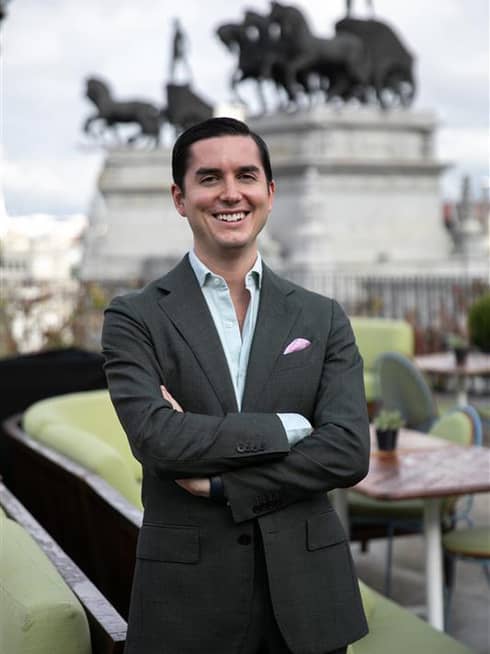 Sebastian Ifergan, standing and smiling with arms crossed
