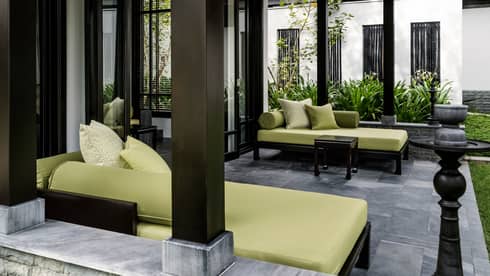 Tropical green sofas on patio pavilion, black and marble pillars, accents