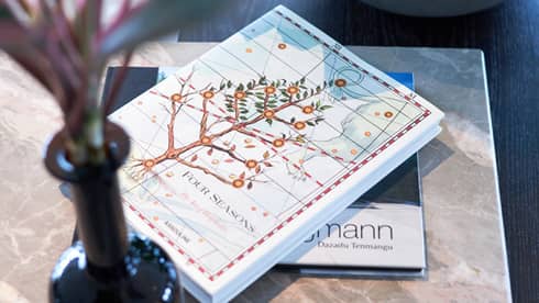 Four Seasons hotel book with an illustrated cover featuring a flowering tree on a table