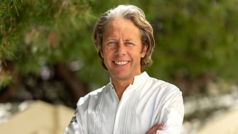 A chef in a white shirt standing in an outdoor setting