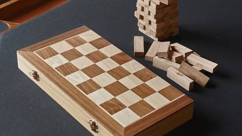 Jenga and a foldable wooden chess board sit on a black card table