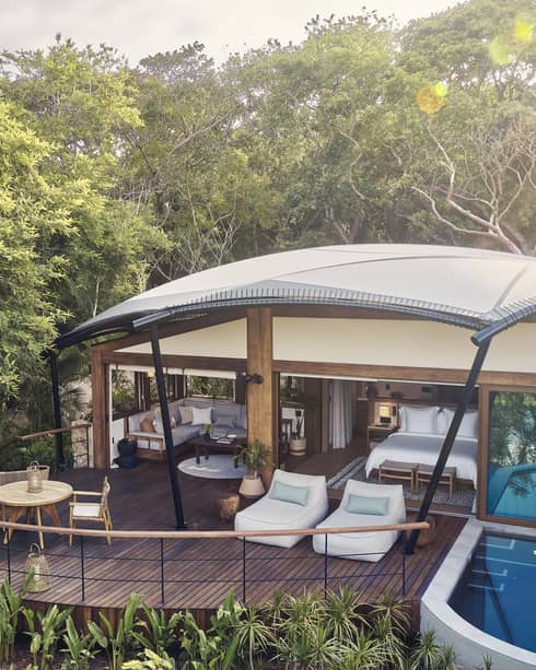 Luxury tent with private plunge pool and deck surrounded by tropical forest