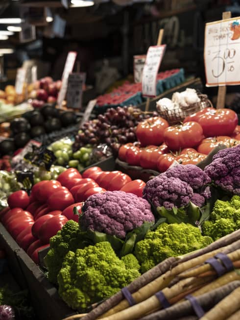 A picture of a vegetable stand in a dimly lit space.