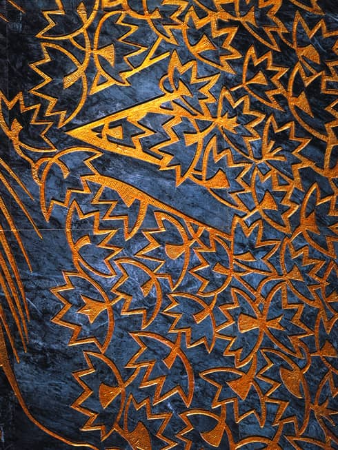 Close-up of orange leaf pattern facade over dark blue marble