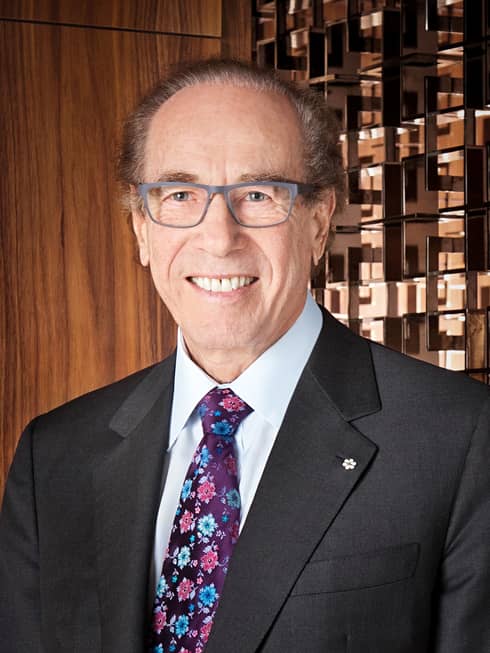 Portrait photo of Four Seasons Hotel Founder and Chairman Isadore Sharp wearing suit, tie