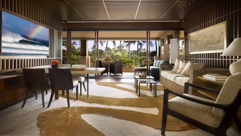 Hotel suite living room opening up to terrace with palm trees