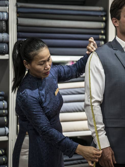 A woman in Hoi An Historical Town tailors a man's suit
