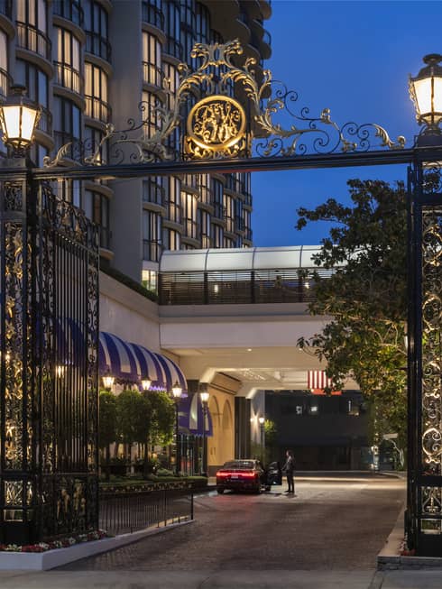 A gate with a golden symbol on top leading to a hotel.