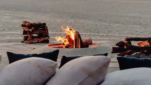 A bonfire on the beach at sunset