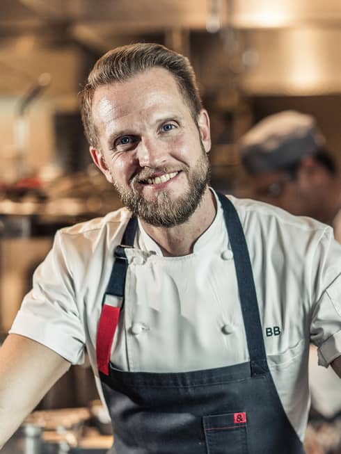 Chef Brian Becher smiles as he works in the CUT kitchen.