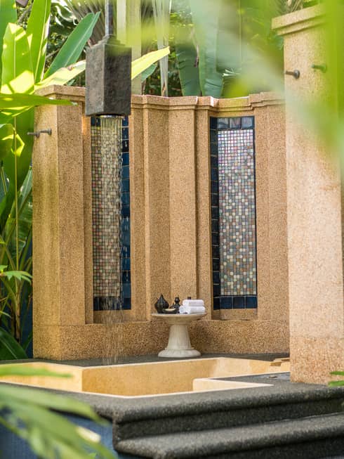 Tile and concrete fountain surrounded by tropical plants