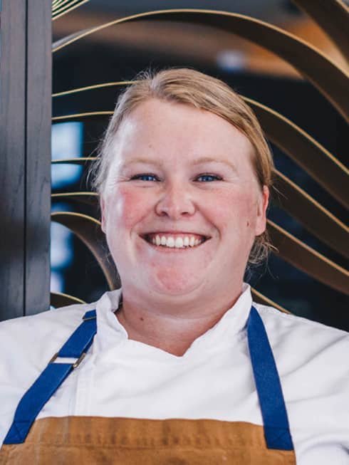 A smiling chef in an apron.