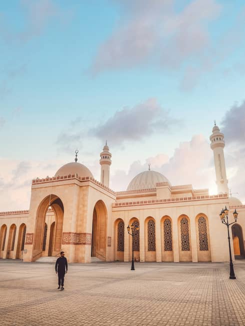 A large tan mosque with several pillars.
