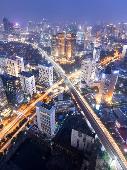 Aerial view of Jakarta city buildings and highways lit up at night