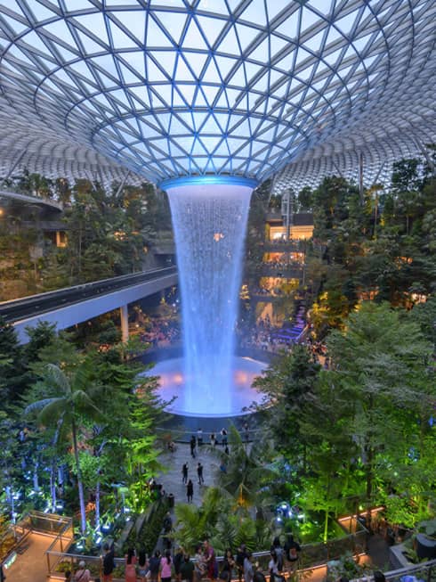 An arial view of an indoor garden with a large fountain in the center in singapore