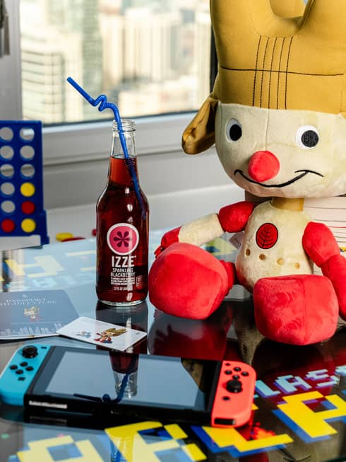 A stuffed animal, games, an electronic and popcorn on a table.
