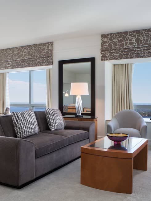 Grey sofa, armchairs in corner suite with large windows