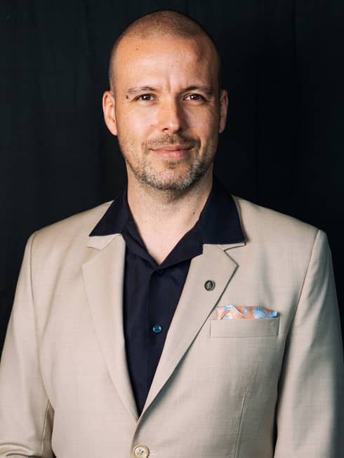 Alexandre Renoue wearing a button down shirt and blazer.
