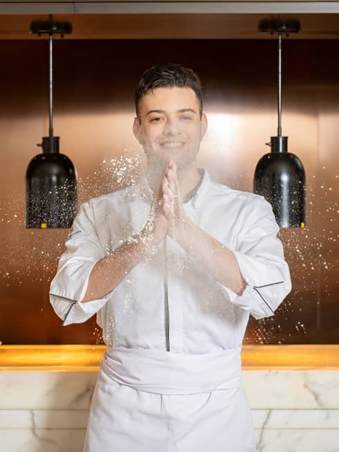 Chef Ivan Spadaro claps flour-covered hands together