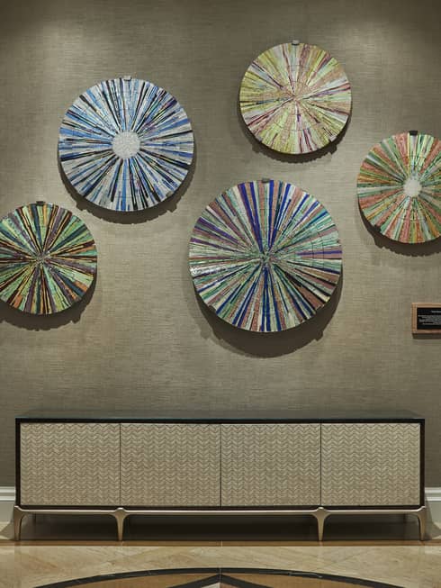 Spa wall with colourful disc art mounted on wall over console table