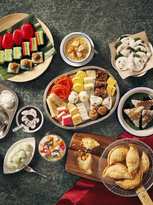 An overhead view of an array of food – dips and vegetables, empanadas and fruit – on a table