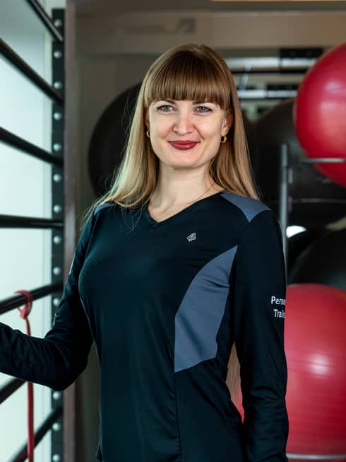 A female fitness instructor near a wall.