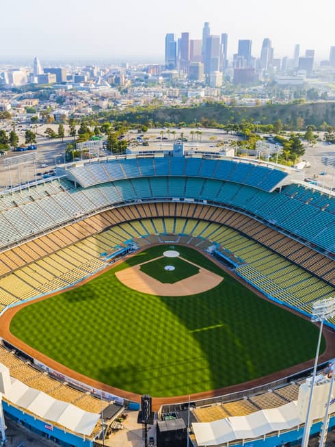 An aerial view of the Dodgers baseball stadium with Los Angeles skyscrapers in the background