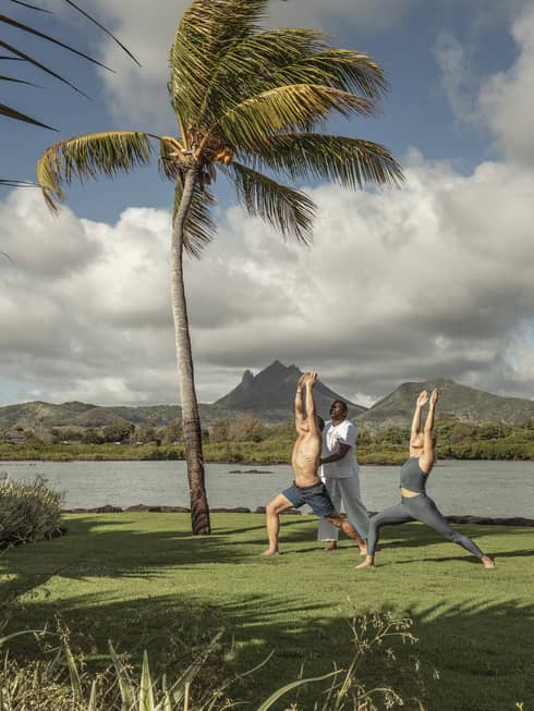 Yogi teaches a couple oceanfront yoga