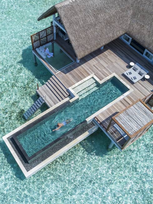 Aerial view of water villa with long swimming pool over lagoon
