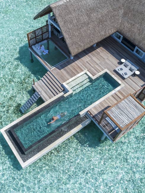 Aerial view of water villa with long swimming pool over lagoon