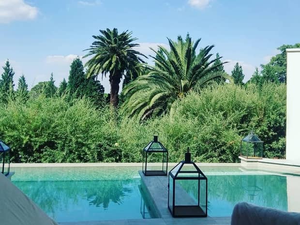 Lanterns on outdoor swimming pool under large palm trees