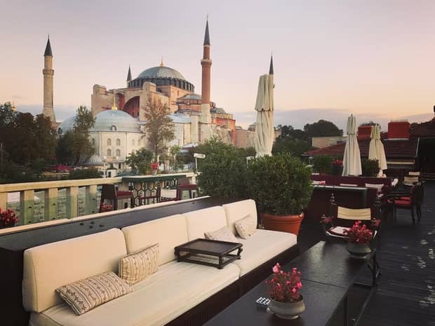 Plush white patio sofa on outdoor lounge overlooking Istanbul landmarks, city skyline