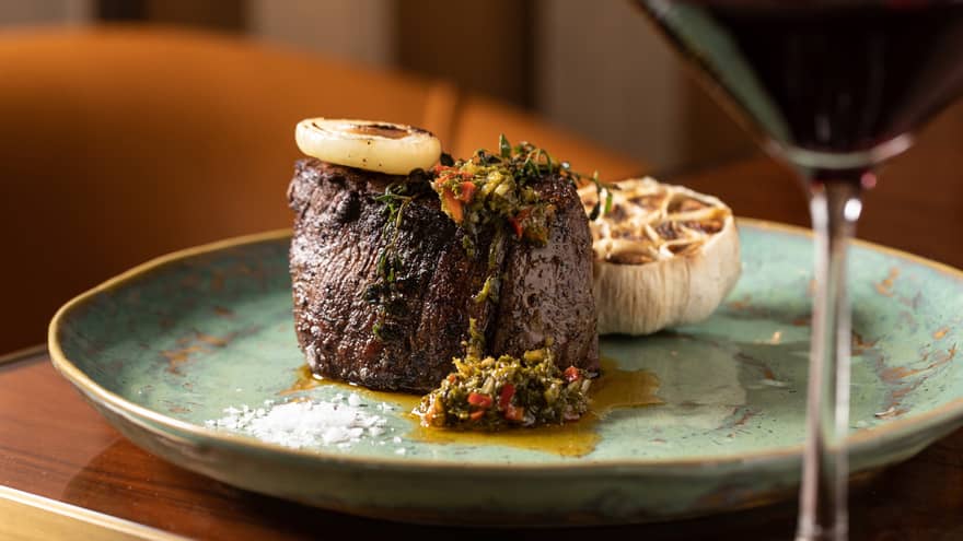 A filet mignon served with roasted garlic and topped with sauce