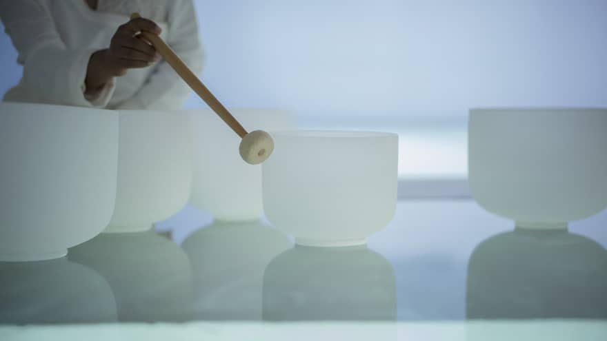 Woman plays singing crystal bowls at the Spa