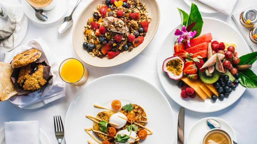 Aerial view of gourmet brunch dishes, fresh fruit platters arranged on table