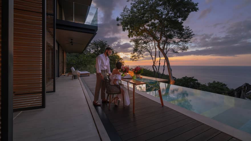 Man and woman on outdoor terrace next to infinity pool