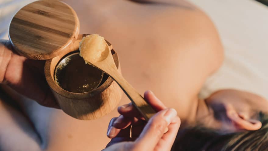 A spa scrub is placed on a guest's back during a relaxing treatment