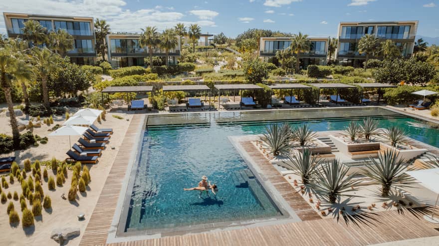 A couple stands in a large resort pool
