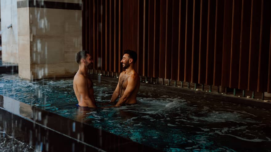 A couple stands in a spa pool together