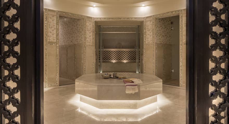 Hammam room with illuminated under lighting, beige marble