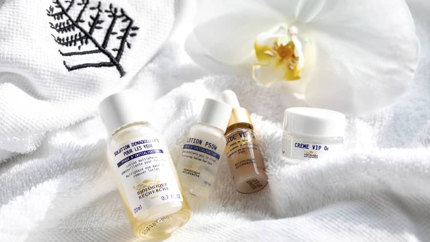 In-room toiletry bottles displayed on a FS complimentary white robe