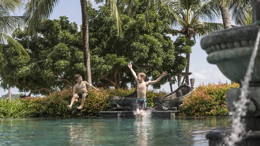Two little boys jumping into the family pool at Four Seasons Langkawi