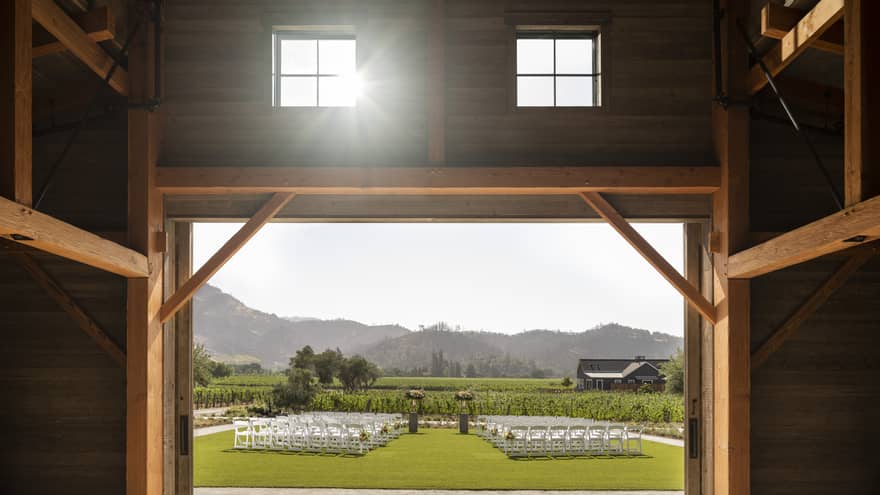 Barn doors opening up to lawn set up for wedding ceremony