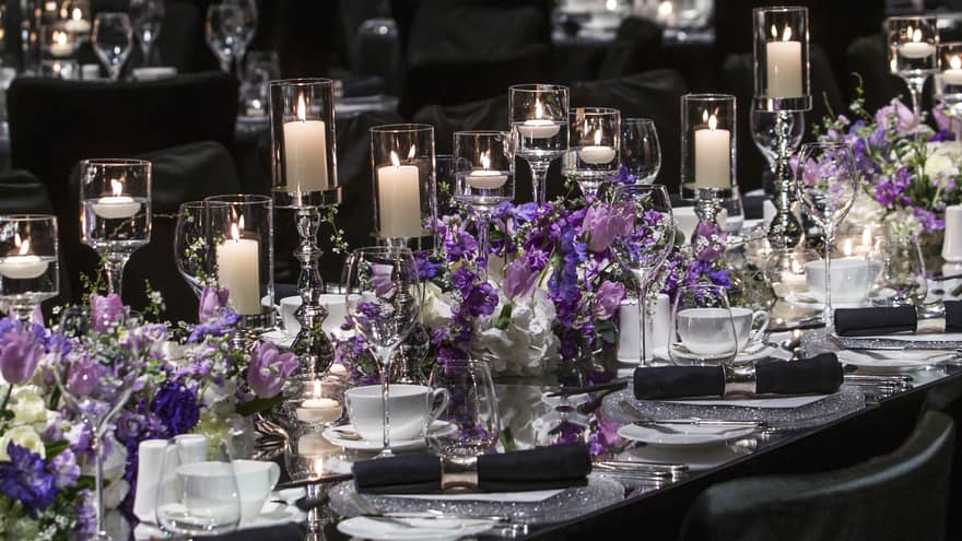 Many candles on table setting for luxury wedding with black decorations